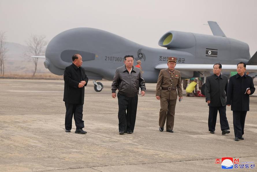 North Korean leader Kim Jong Un walks alongside officials, while guiding defense science research projects, according to local media, at an unknown location
