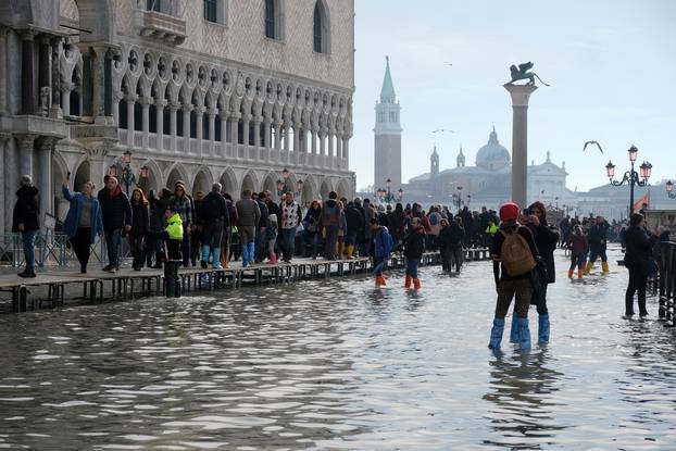 Tourists walk in St. Mark’s Square after days of severe flooding in Venice