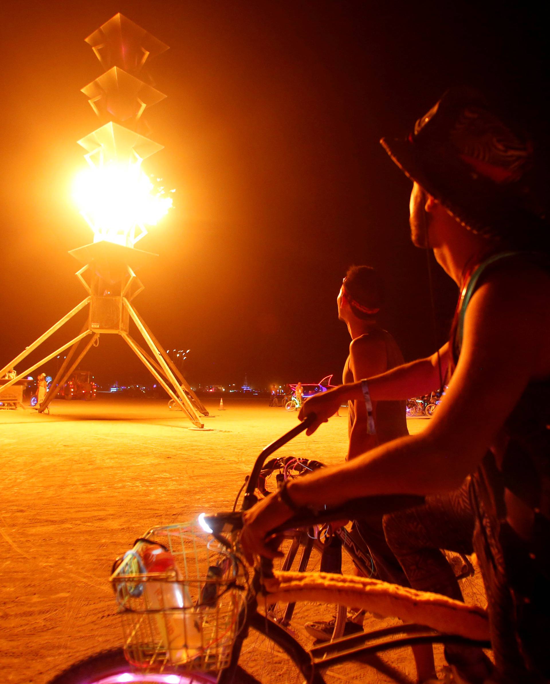 Participants watch the flames on the Spire of Fire as approximately 70,000 people from all over the world gather for the 30th annual Burning Man arts and music festival in the Black Rock Desert of Nevada