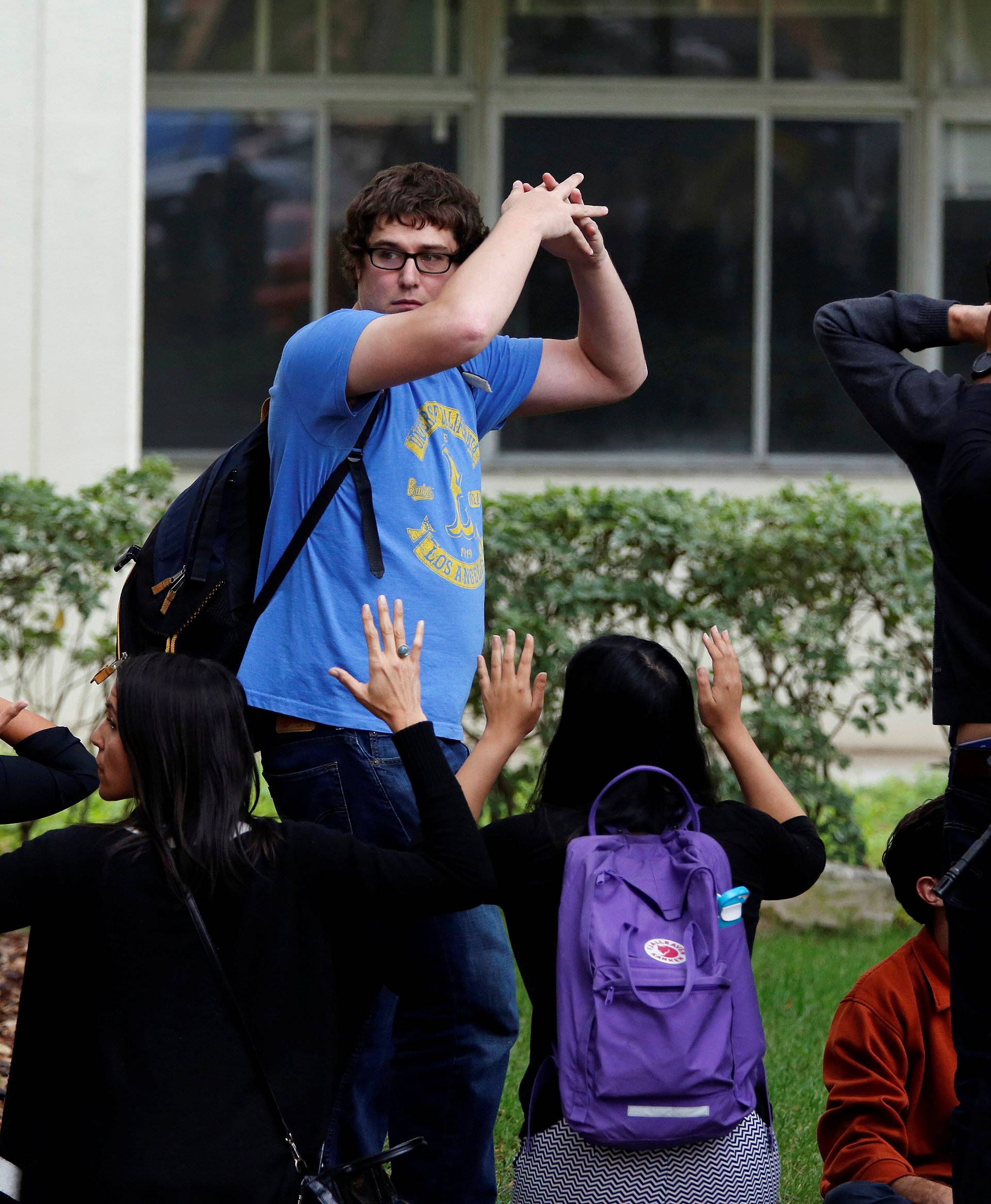 Police officers conduct a search at the UCLA campus after it was placed on lockdown following reports of a shooter that left 2 people dead in Los Angeles, California