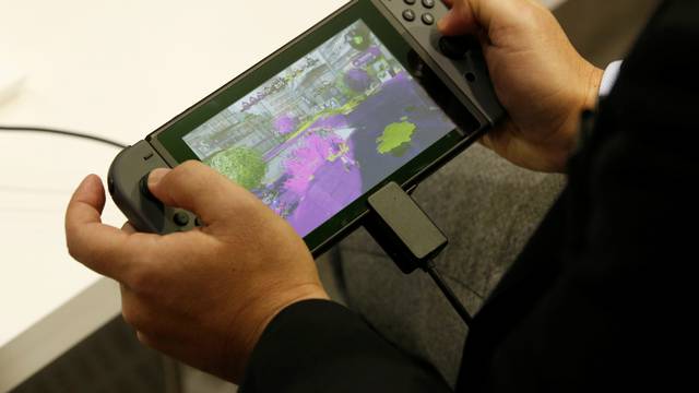 A man plays Nintendo's new game console Switch at its experience venue in Tokyo