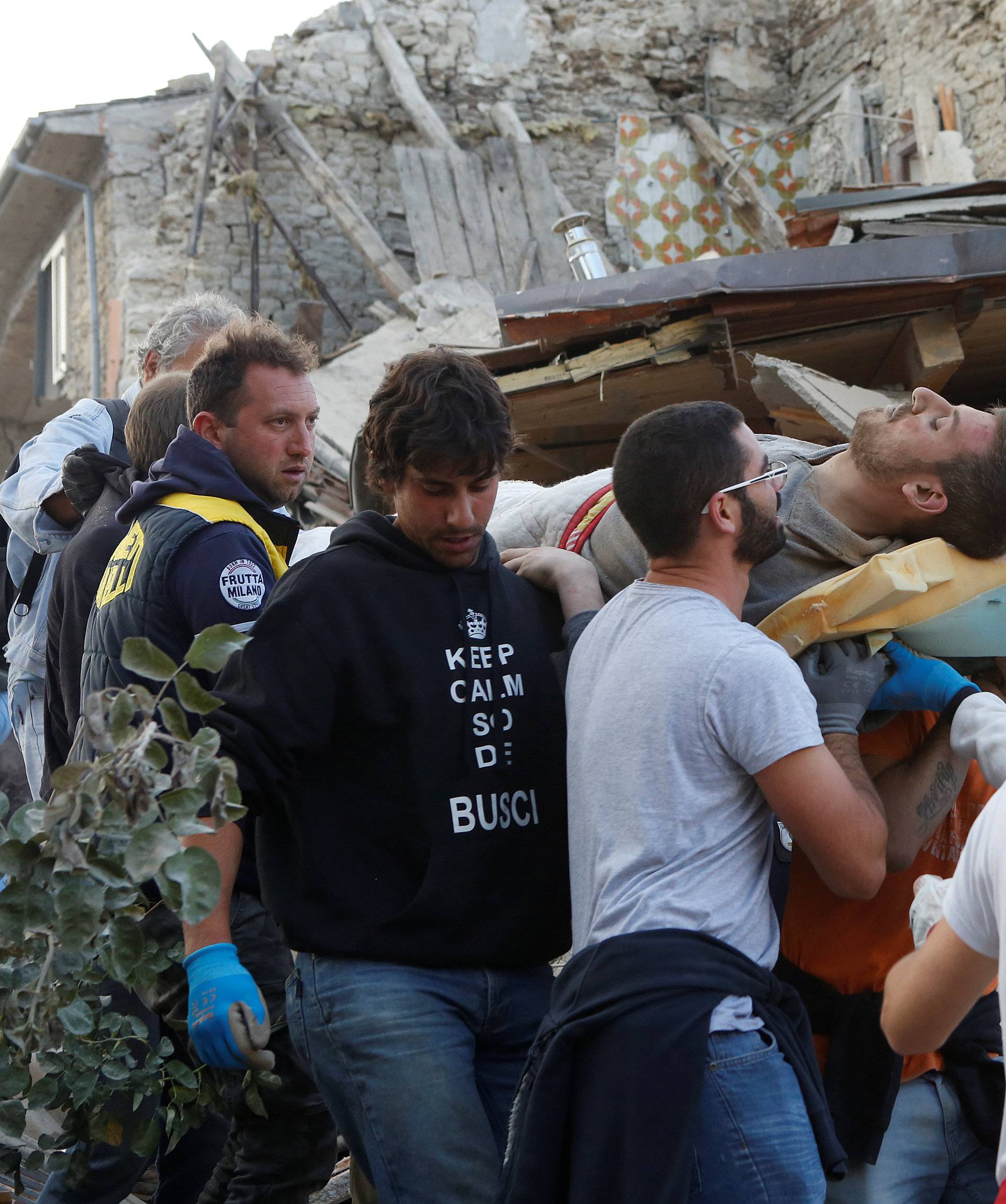 A man is carried away after been rescued alive from the ruins following an earthquake in Amatrice