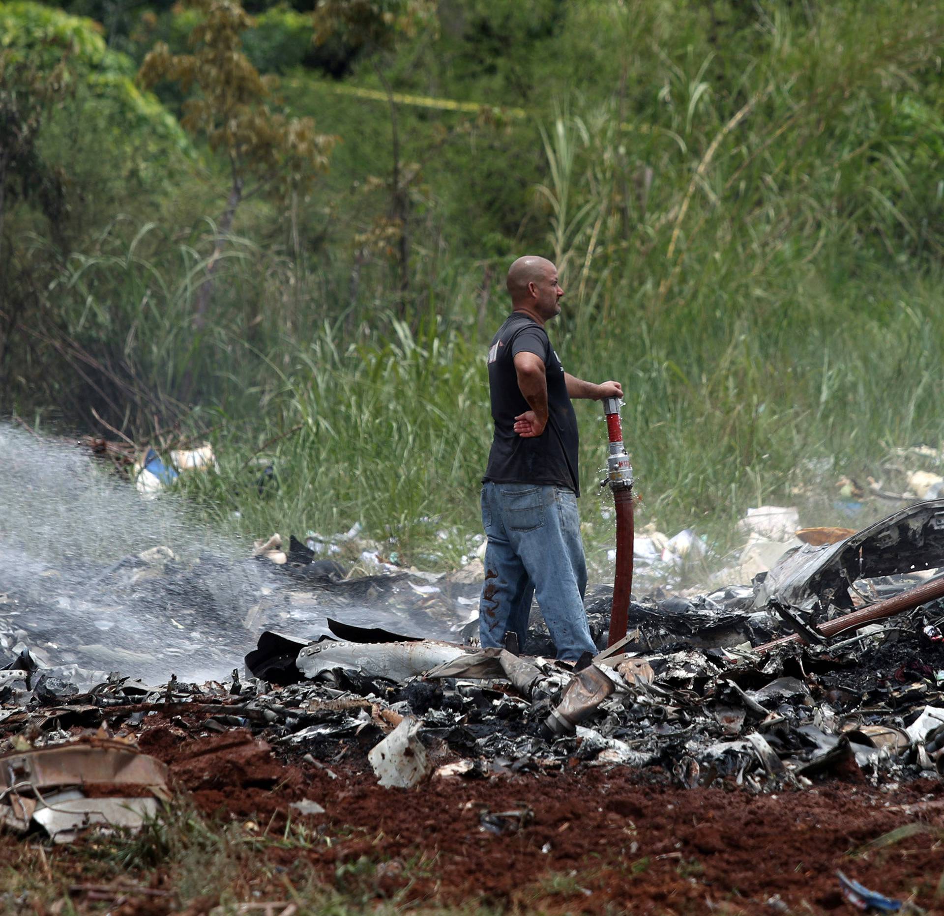 A rescue team member looks on while working in the wreckage of a Boeing 737 plane that crashed in the agricultural area of Boyeros