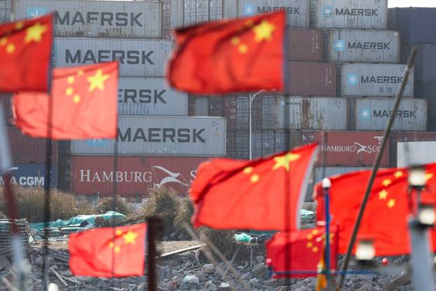 FILE PHOTO: Chinese national flags flutter near shipping containers at the Yangshan Port outside Shanghai