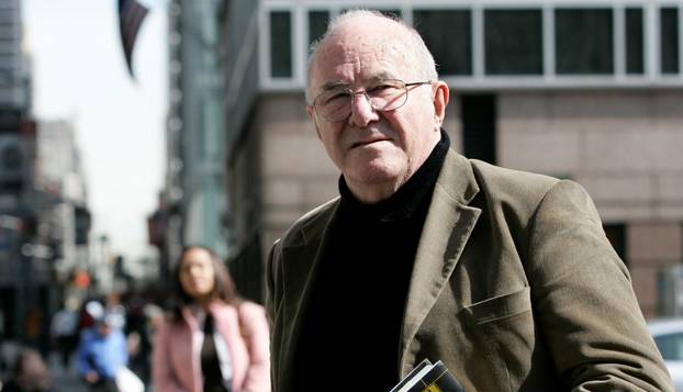 FILE PHOTO: Author Clive James poses with copy of his latest book "Cultural Amnesia" in New York