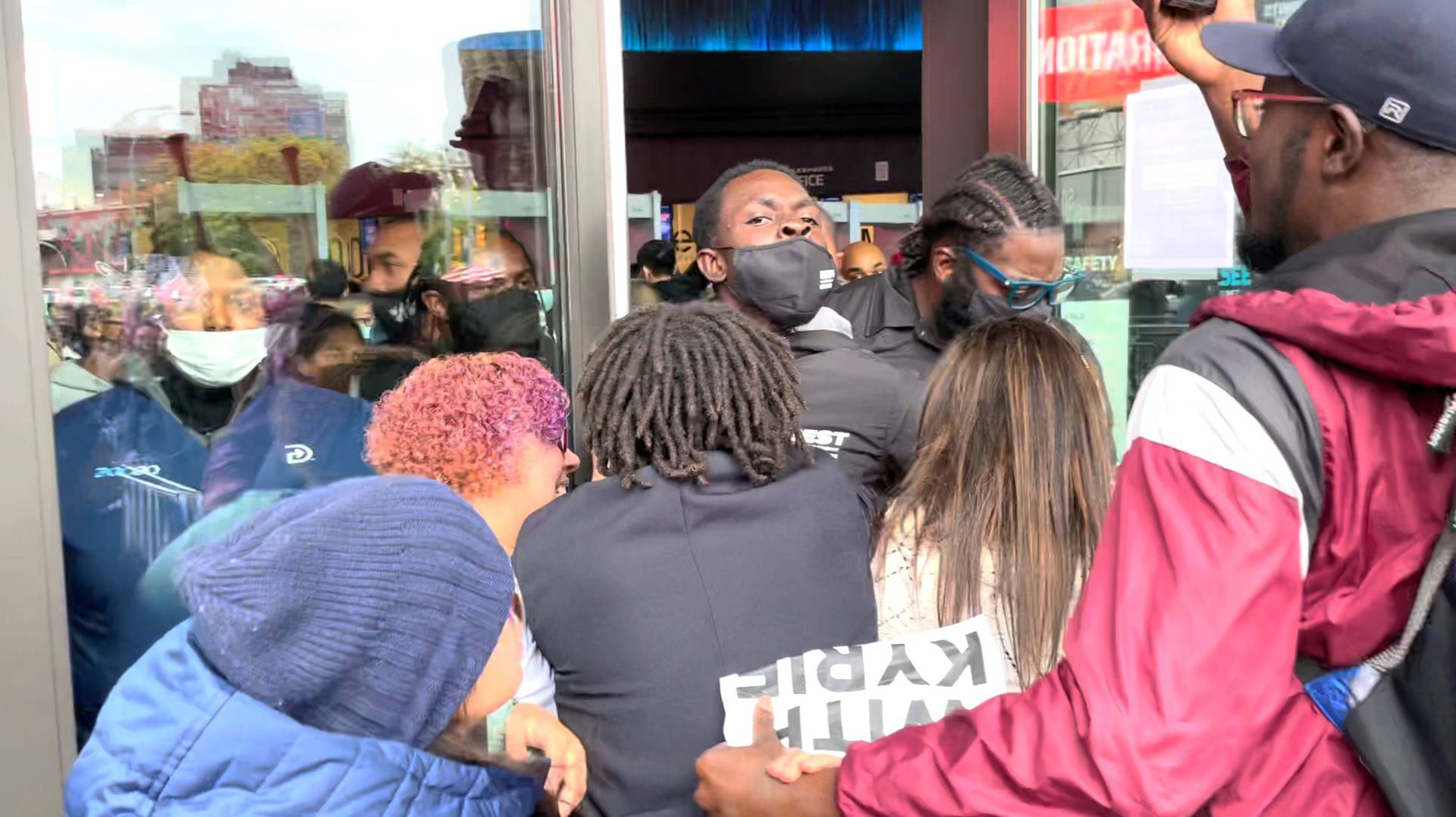 Demonstrators rush through the doors of the Barclays Center as security officers hold them off in New York