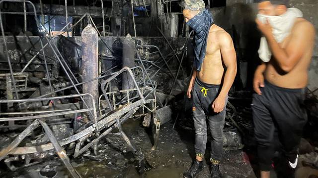 People look on at Ibn Khatib hospital after a fire caused by an oxygen tank explosion in Baghdad