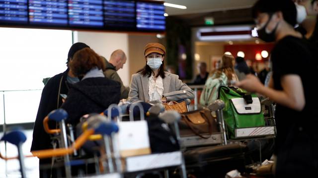 Travellers wearing masks arrive on a direct flight from China, in Paris