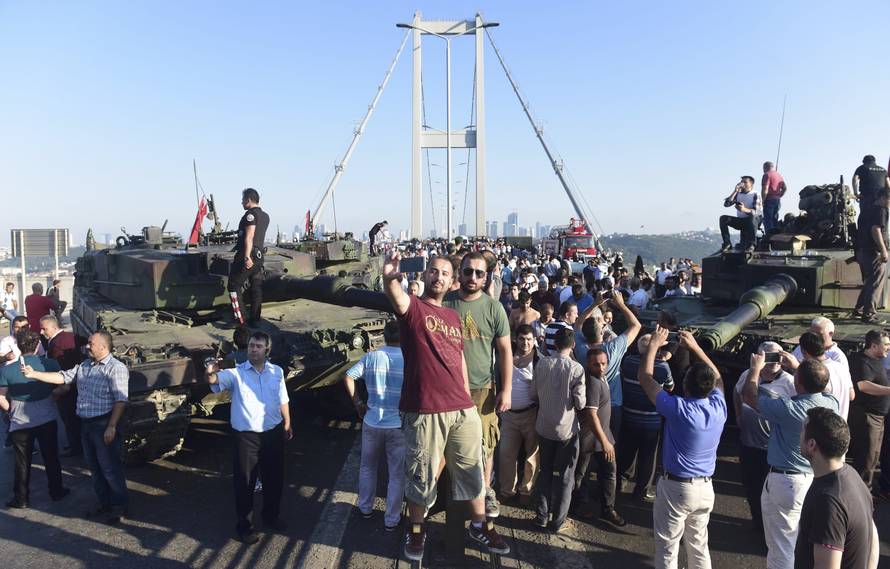 People take selfies after soldiers involved in the coup surrendered on the Bosphorus Bridge in Istanbul