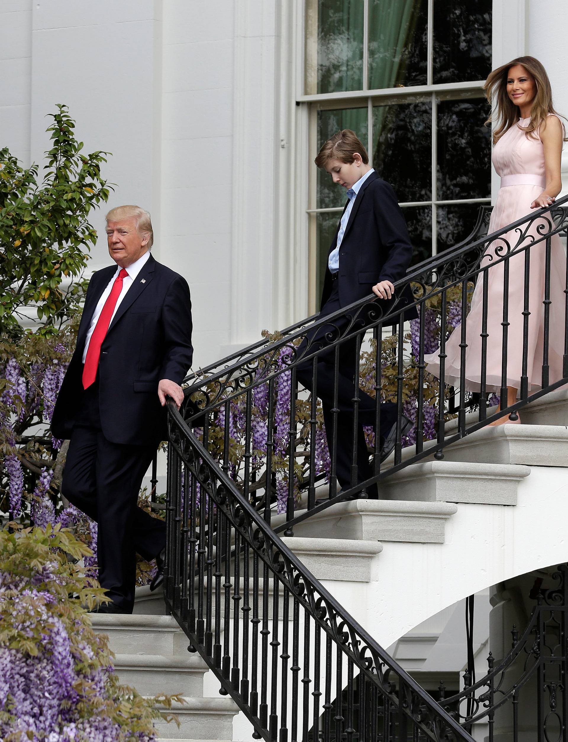 U.S. President Donald Trump, U.S. first lady Melania Trump and their son Barron descend a staircase during the 139th annual White House Easter Egg Roll on the South Lawn of the White House in Washington