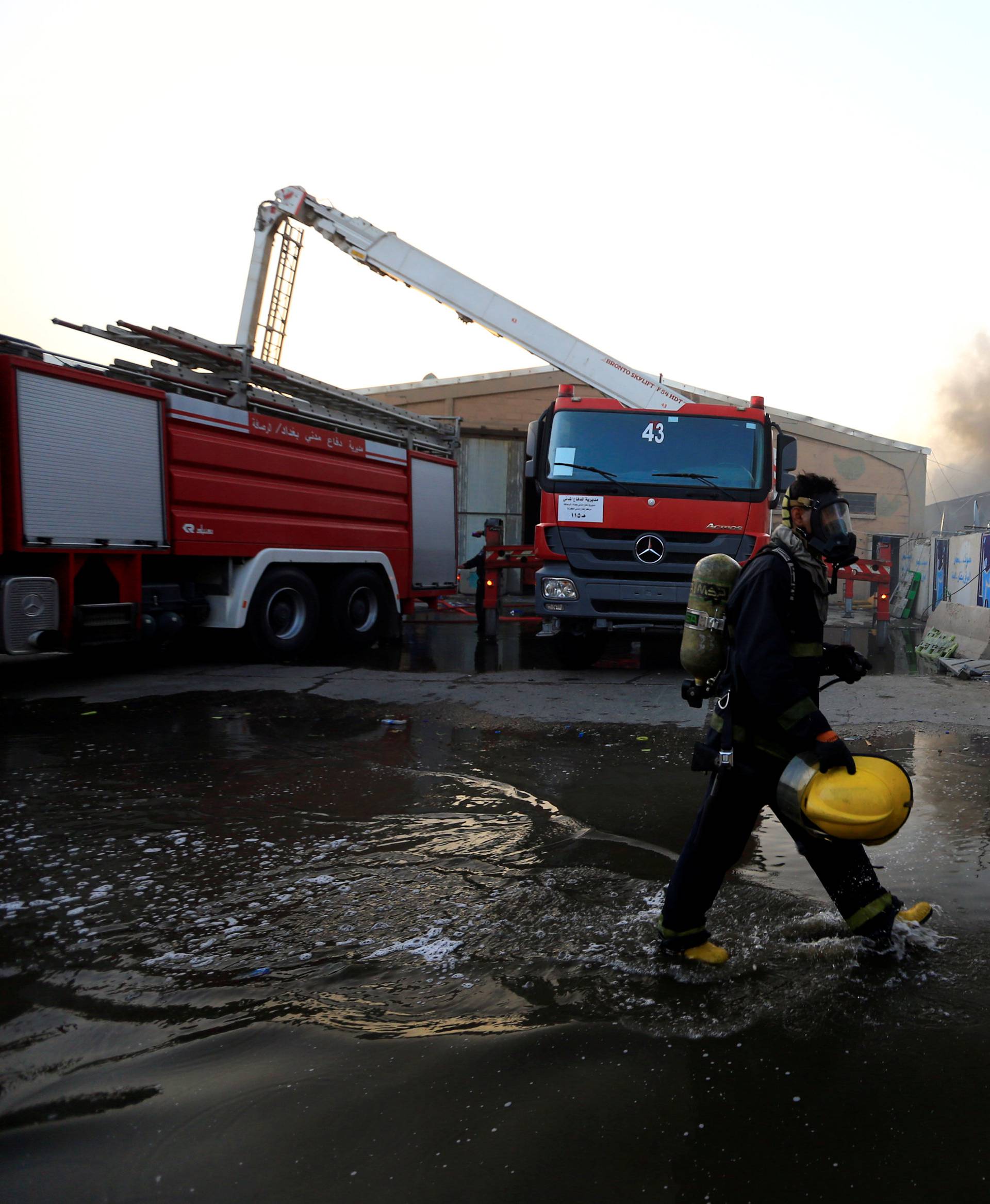 Firefighter is seen after a fire at a storage site in Baghdad, housing the boxes from Iraq's May parliamentary election