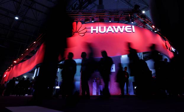 FILE PHOTO - Visitors walk past Huawei