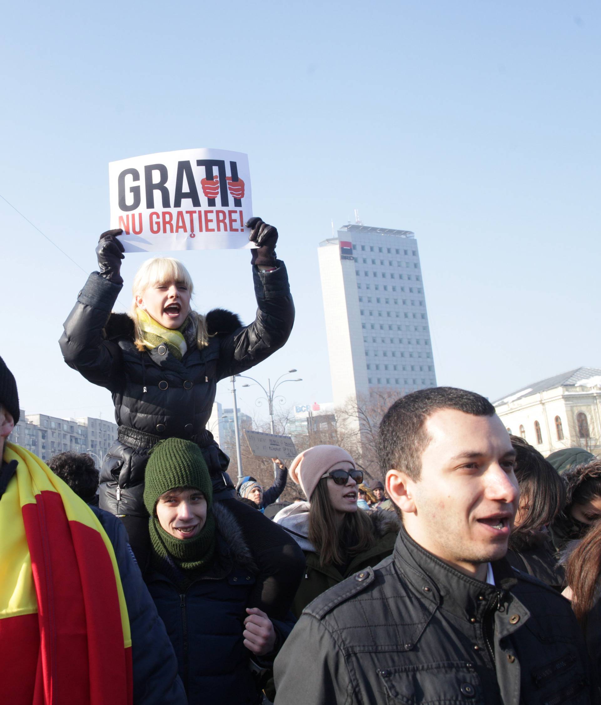 A woman holds a sign reading "Bars, not pardon" during a protest in Bucharest