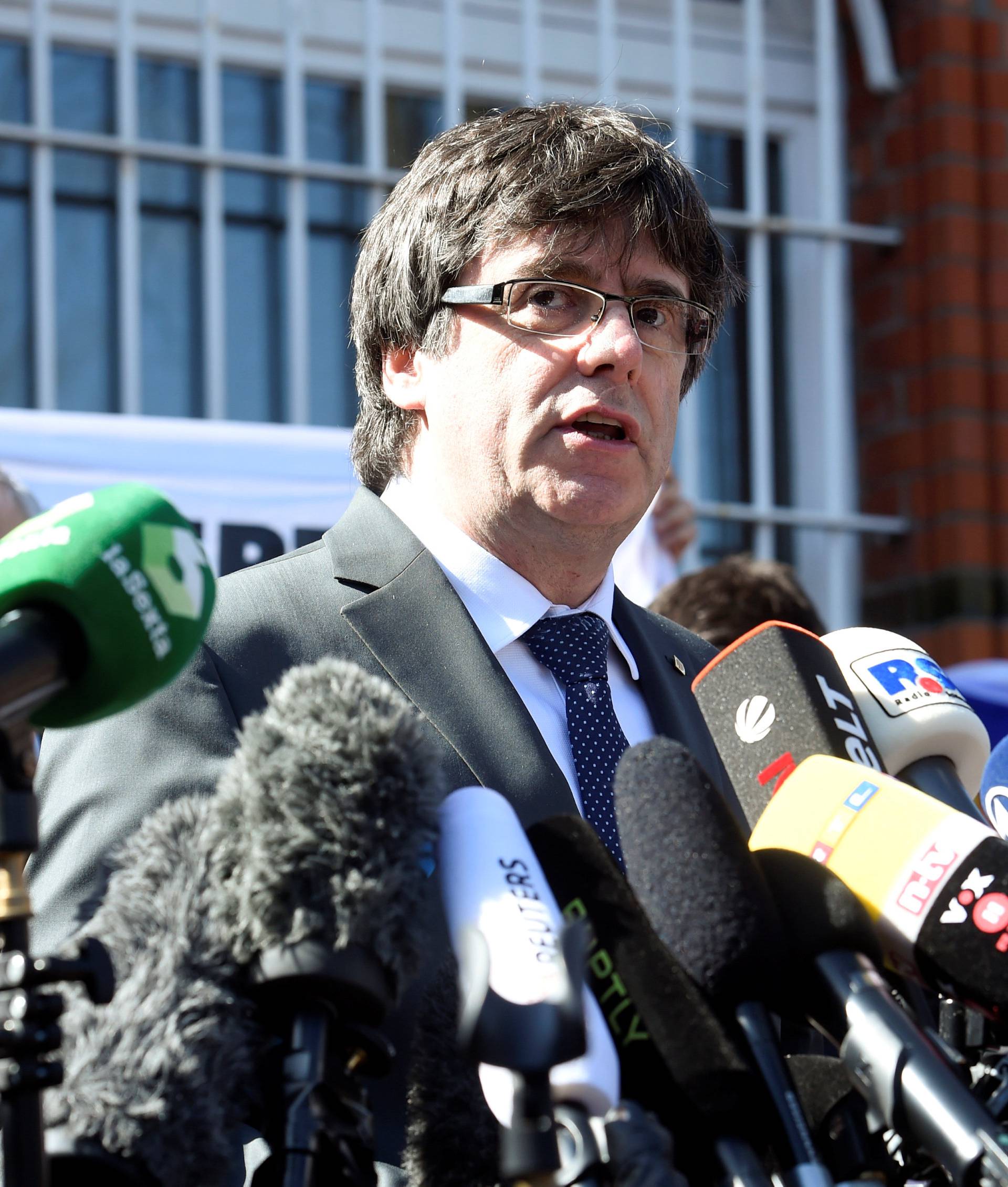 Catalonia's former leader Carles Puigdemont talks to the media as he leaves the prison in Neumuenster