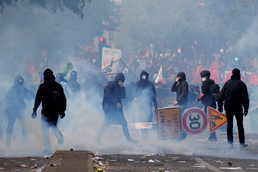Tear gas surrounds protesters during clashes with French riot police at the May Day labour union rally in Paris