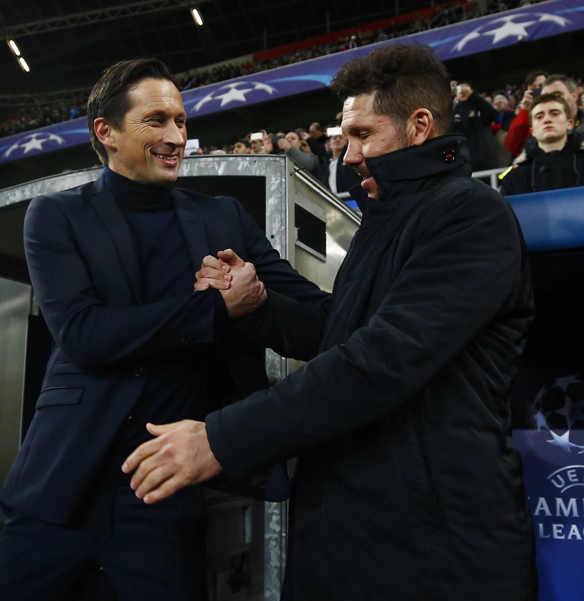 Bayer Leverkusen coach Roger Schmidt greets Atletico Madrid coach Diego Simeone before the match