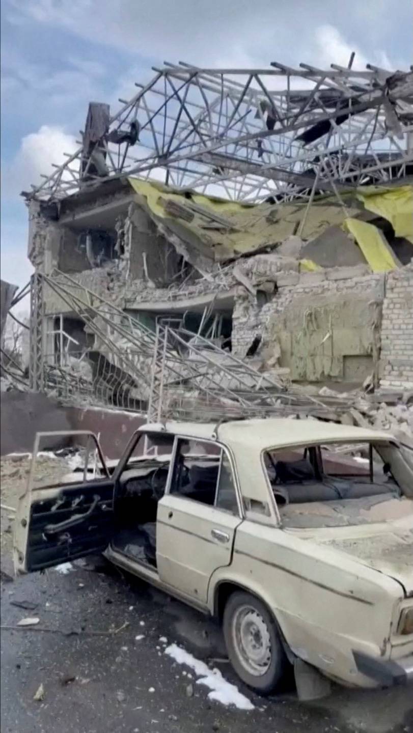 A damaged vehicle is seen outside a destroyed hospital building in Izyum