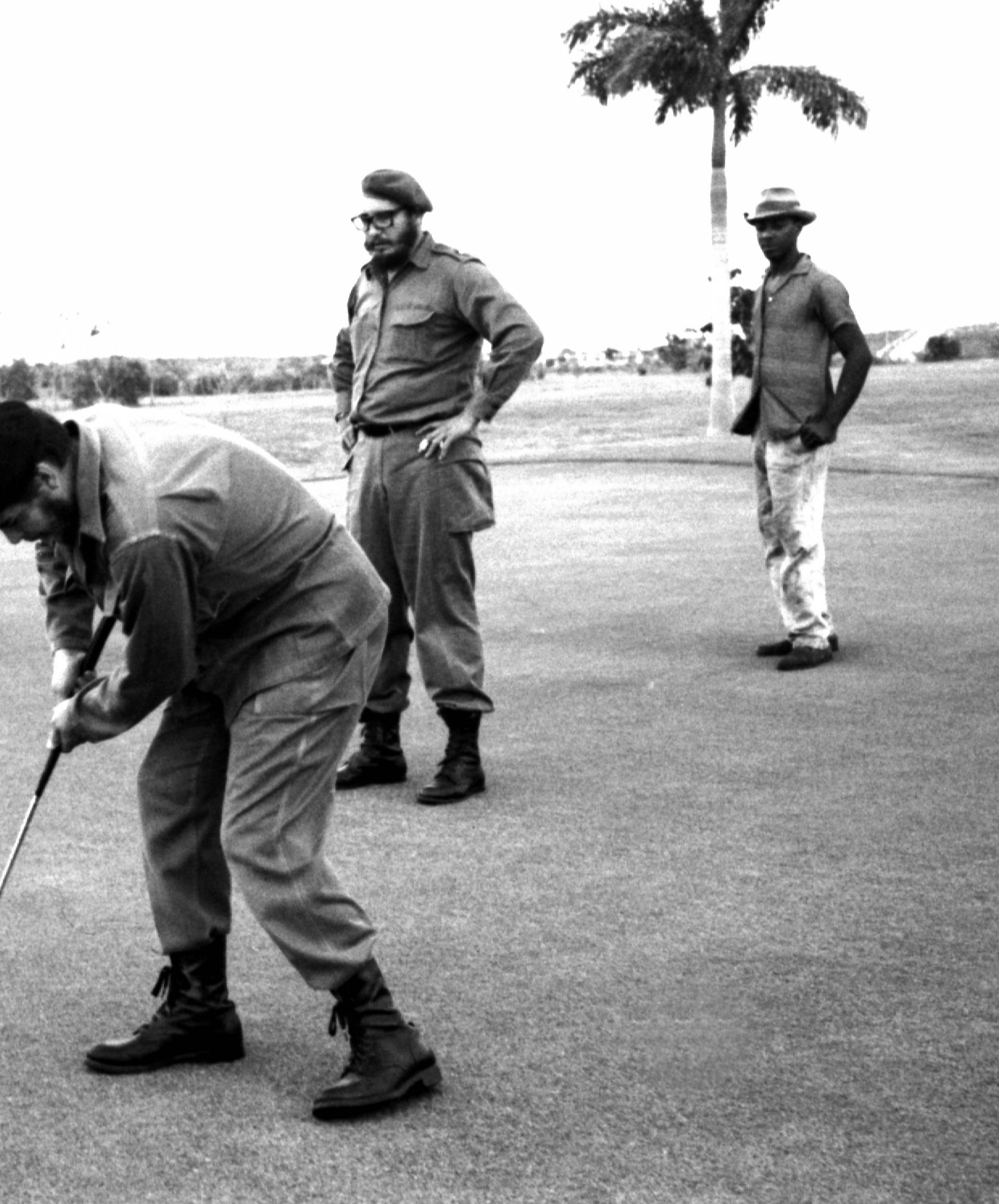 File photo of Ernesto Che Guevara playing golf as Fidel Castro stands behind him at Colina Villareal in Havana