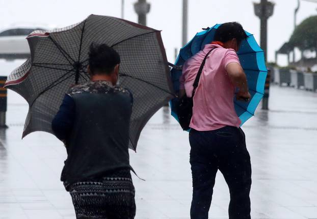 Commuters walk against strong wind caused by Typhoon Haishen in Busan