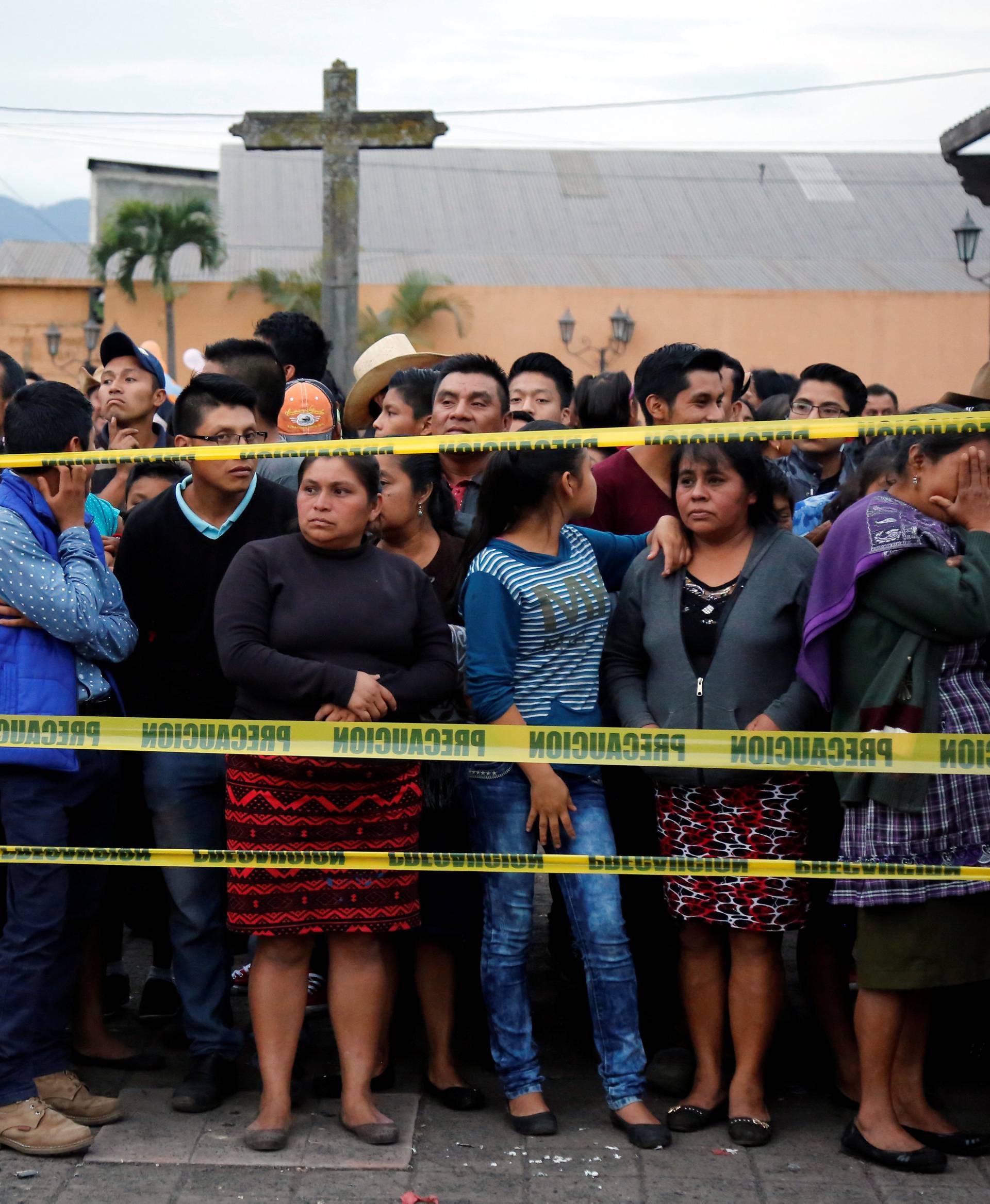 Residents stand behind the cordon line for safety after Fuego volcano erupted violently in San Juan Alotenango