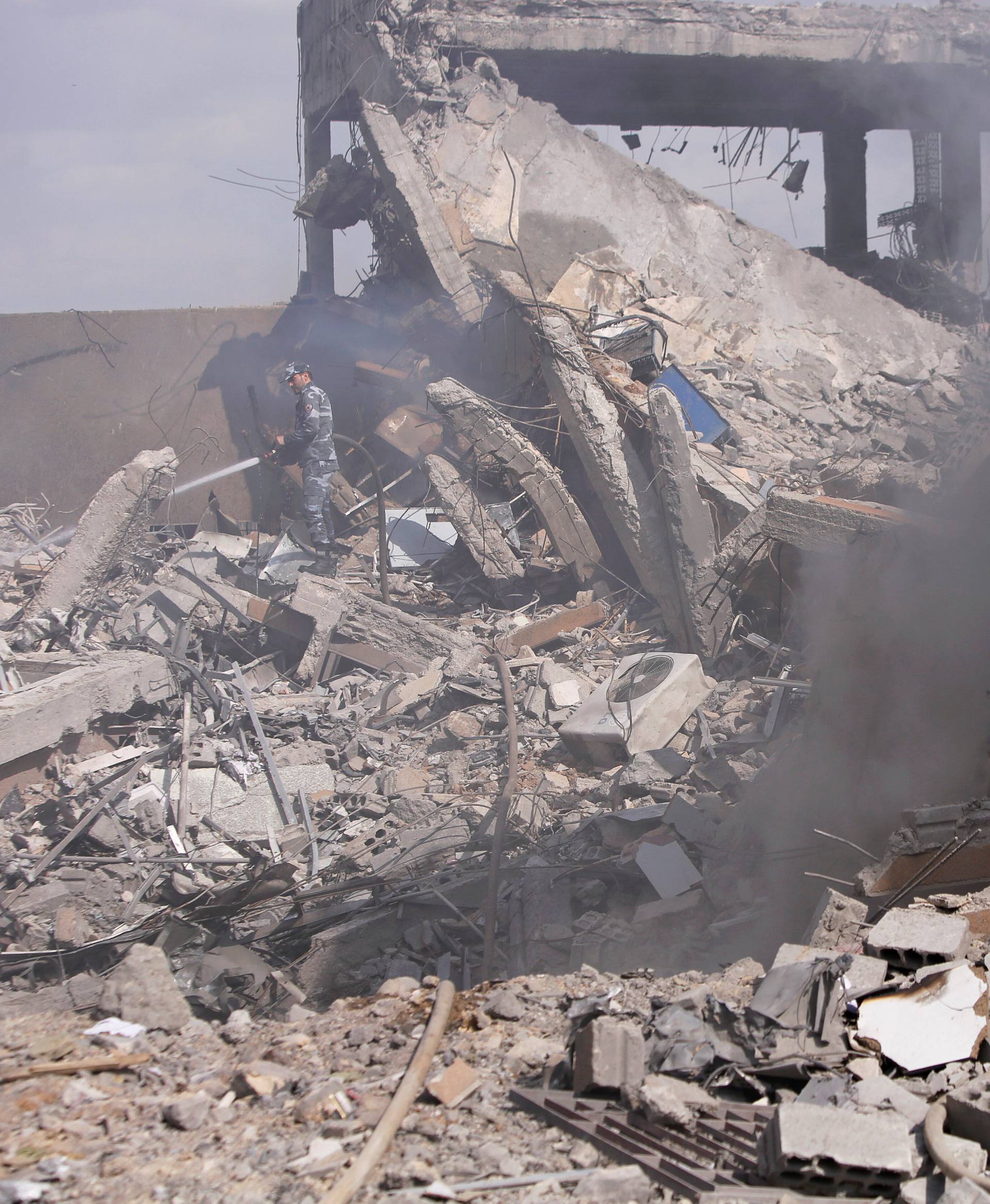 Syrian firefighters are seen inside the destroyed Scientific Research Centre in Damascus