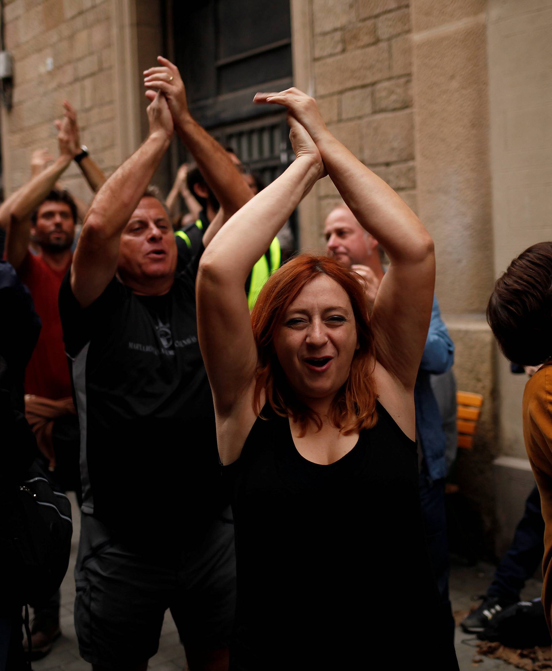 People shout the slogan "We will win, we will vote, we have voted" after casting their votes in a polling station for the banned independence referendum in Barcelona