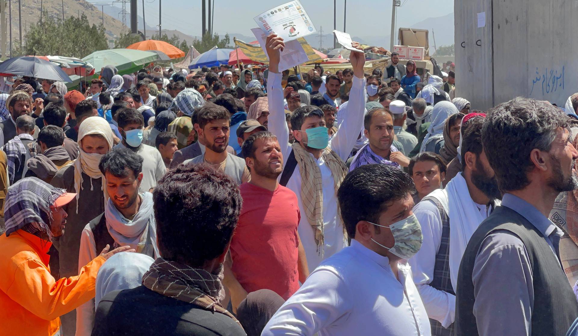 FILE PHOTO: Crowds of people show their documents to U.S. troops outside the airport in Kabul