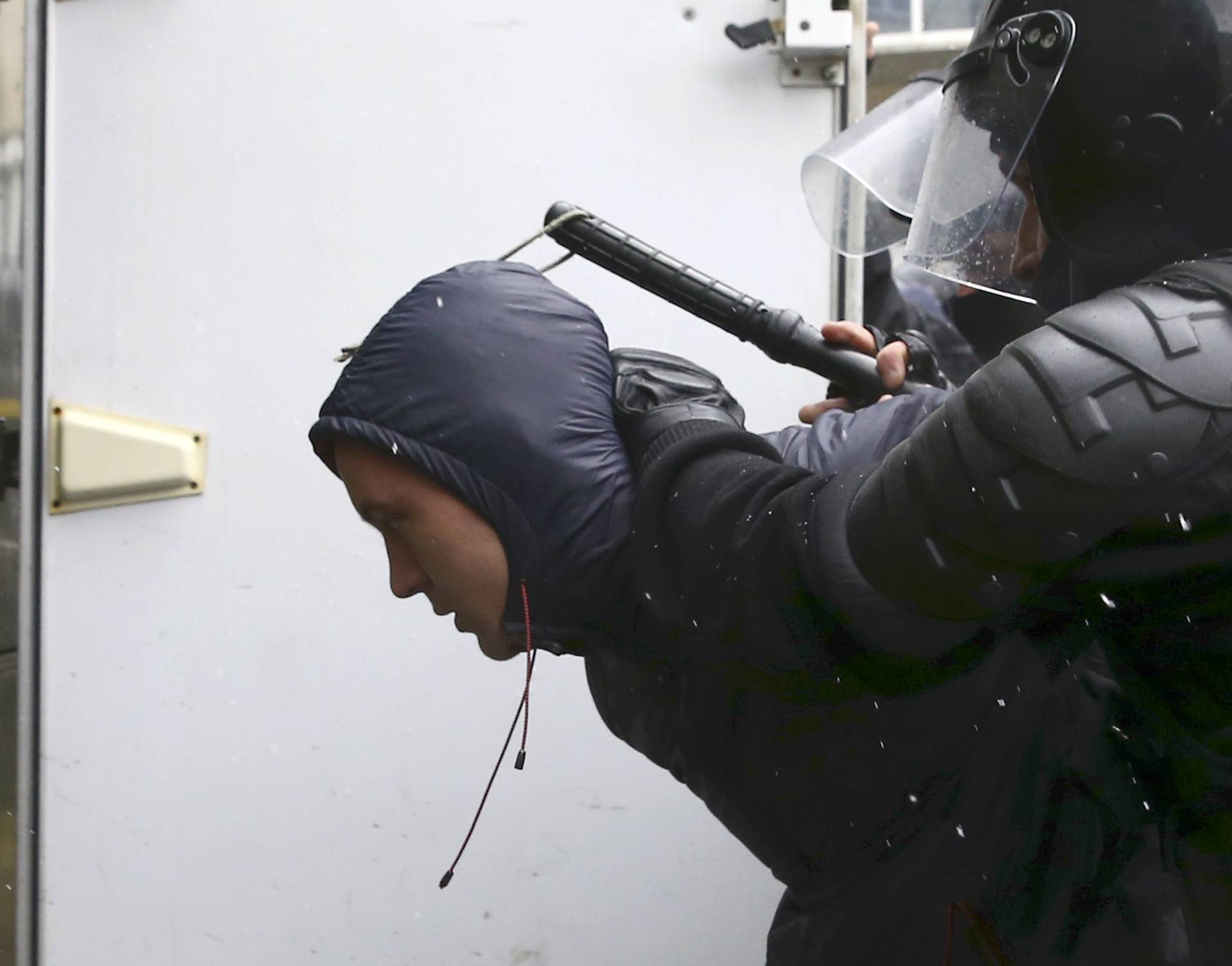 Law enforcement officers detain a man during a gathering which marks the anniversary of the proclamation of the Belarussian People's Republic in Minsk