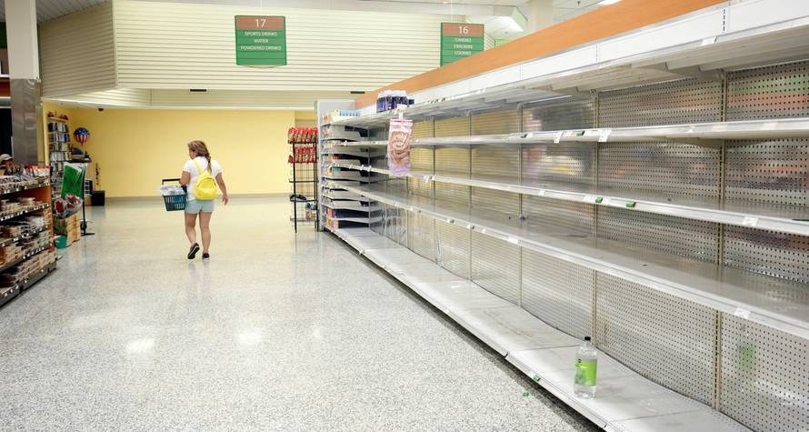 A shopper walks past empty shelves at a supermarket ahead of Hurricane Irma making landfall in Kissimmee