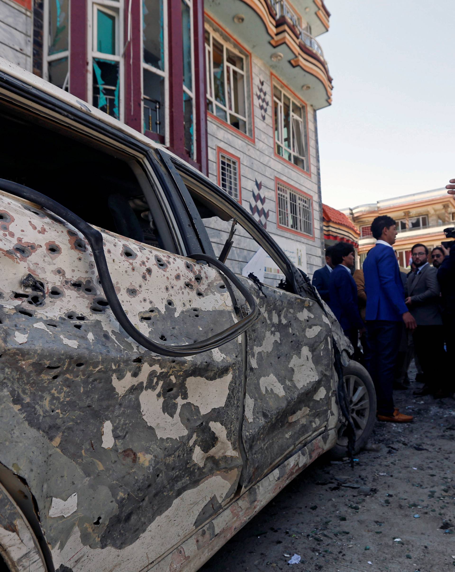 Afghan men inspect the site of a suicide bomb blast in Kabul