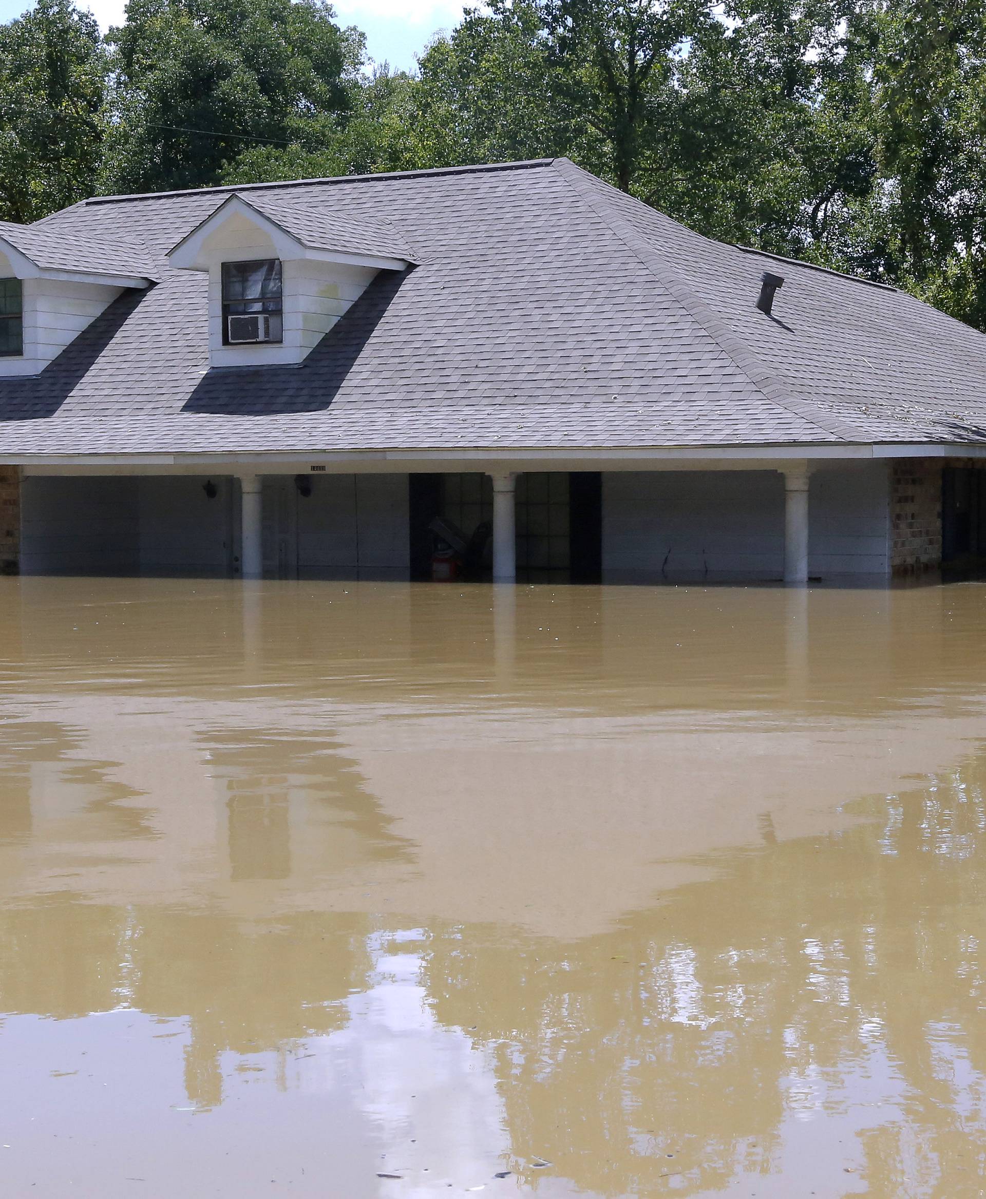 A submerged house is seen in Ascension Parish