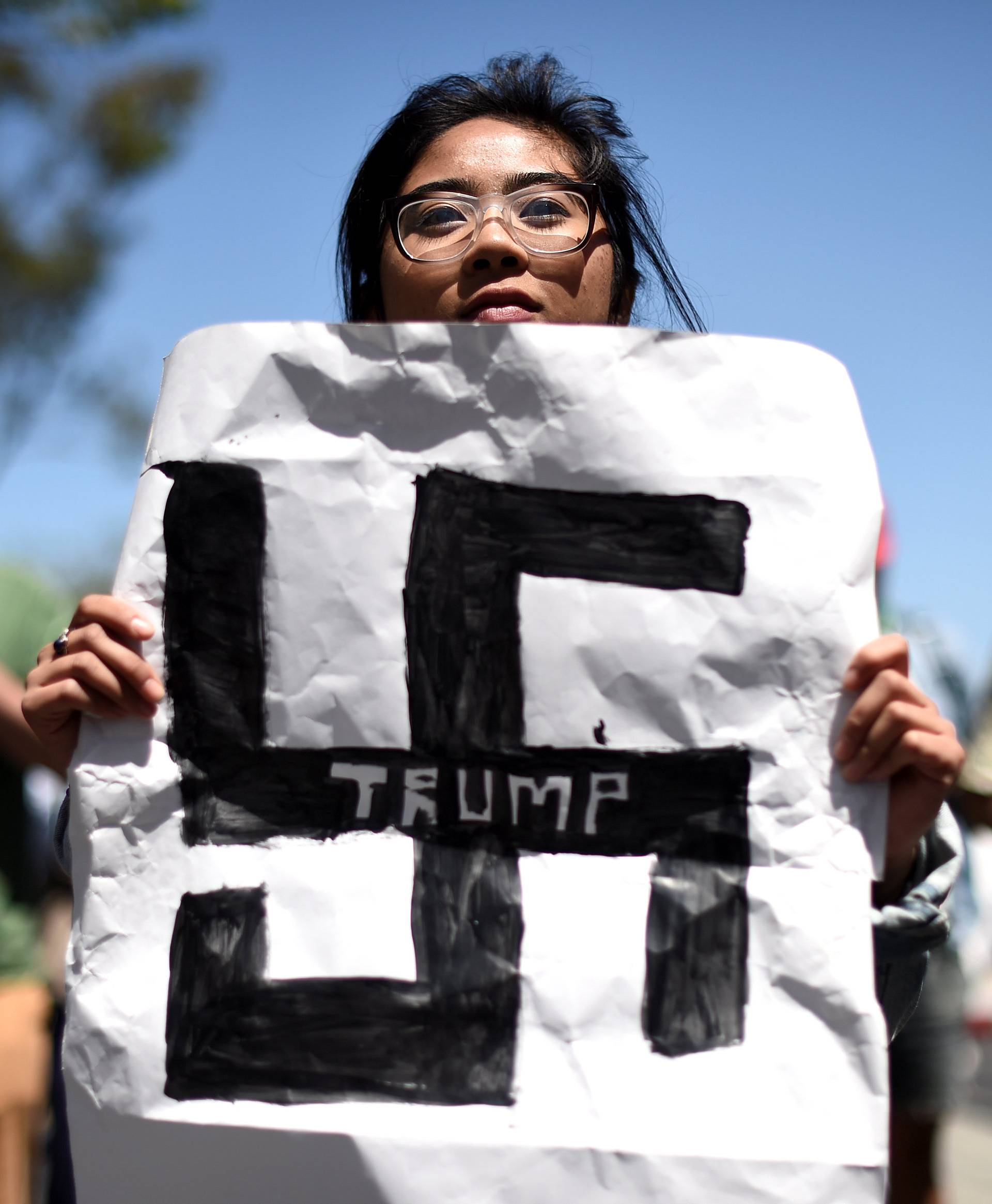 Carla Espinosa holds a protest sign against presidential candidate Donald Trump outside the California Republican Party convention in Burlingame