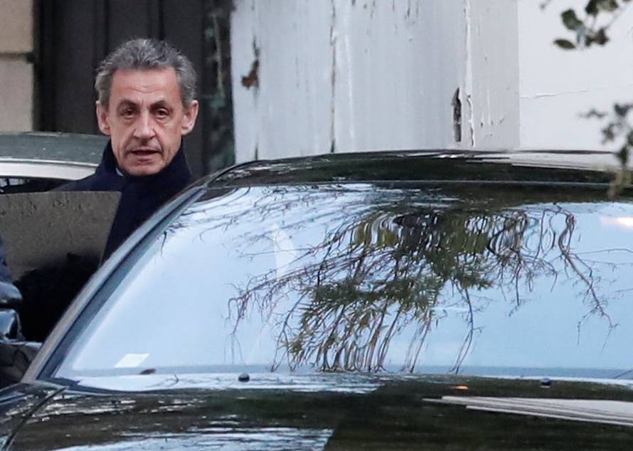 Former French President Nicolas Sarkozy enters his car as he leaves his house in Paris