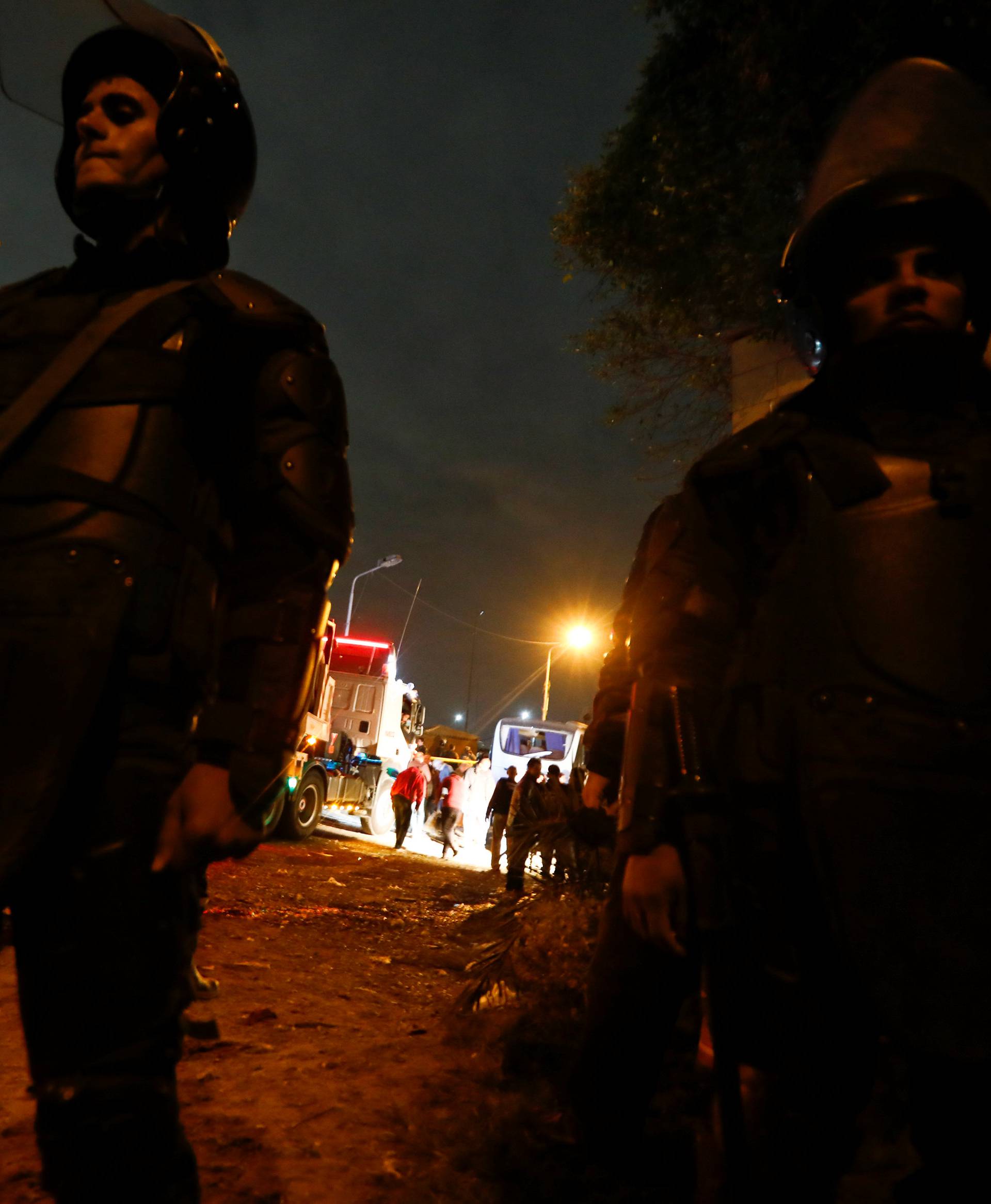 Riot police secure a scene of a bus blast in Giza