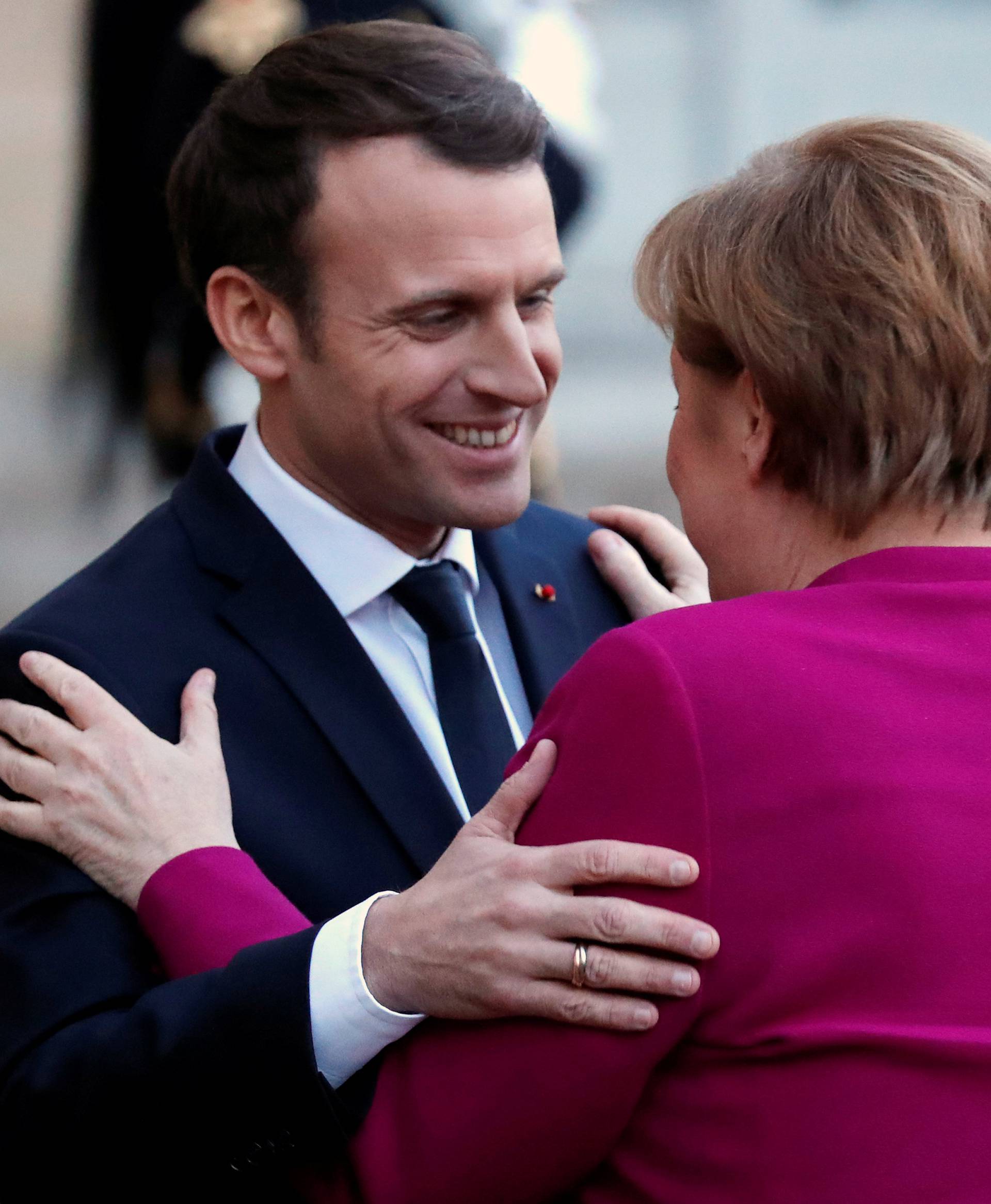French President Emmanuel Macron greets German Chancellor Angela Merkel upon her arrival at the Elysee Palace in Paris