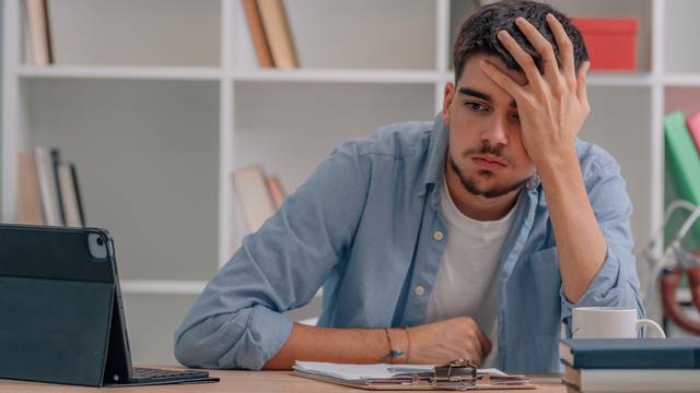 stressed student at home with laptop