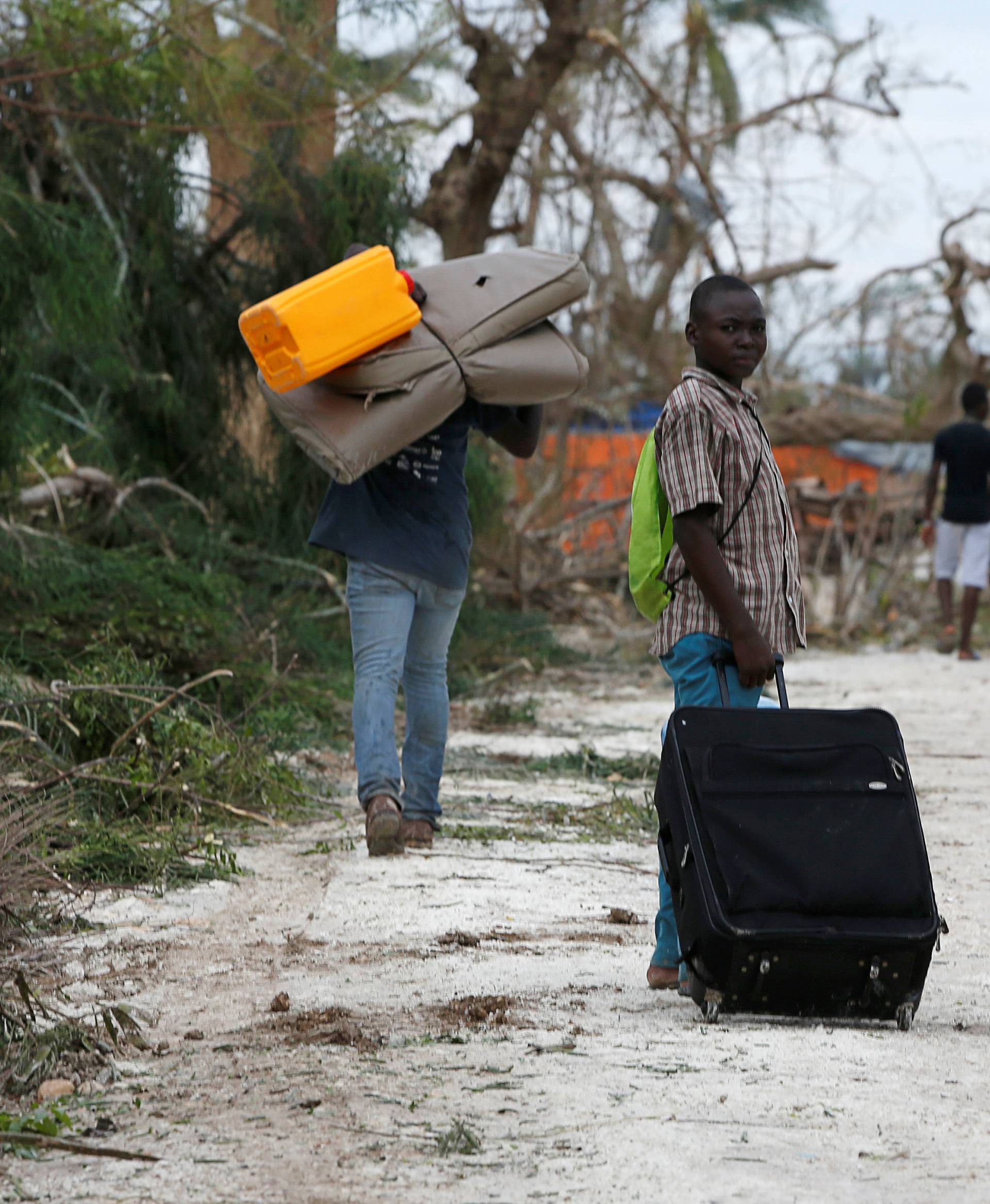 People carry their belongings on the street after Hurricane Matthew passes Jeremie