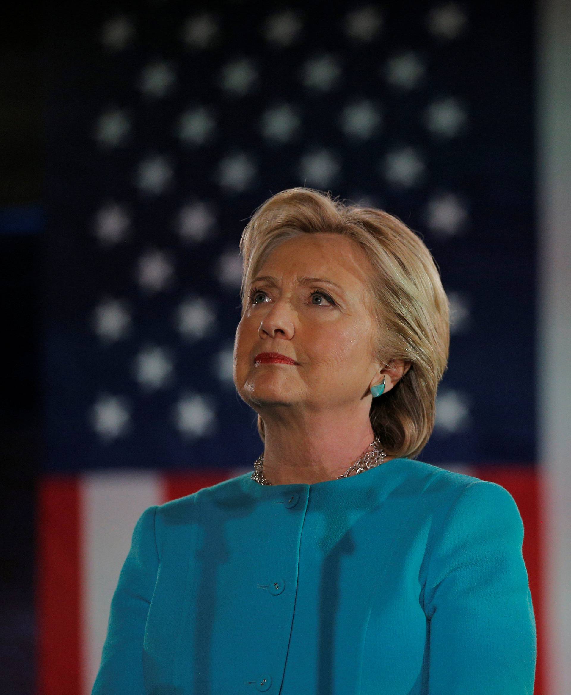 U.S. Democratic presidential nominee Hillary Clinton listens as she is introduced by Gold Star father Khizr Khan at a campaign rally in Manchester