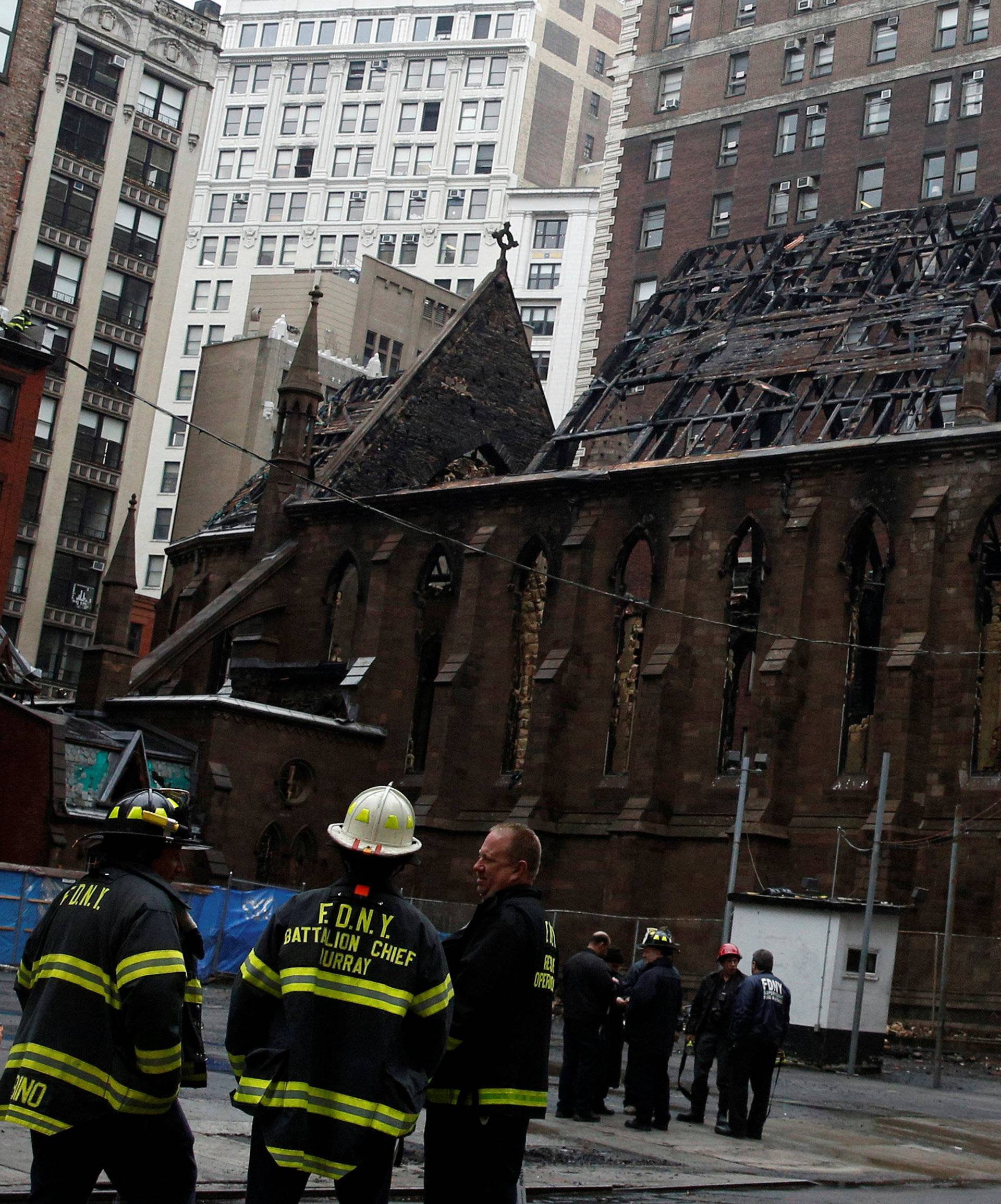 New York City firefighters (FDNY) stand in front of Manhattan's historic Serbian Orthodox Cathedral of Saint Sava following a fire in New York