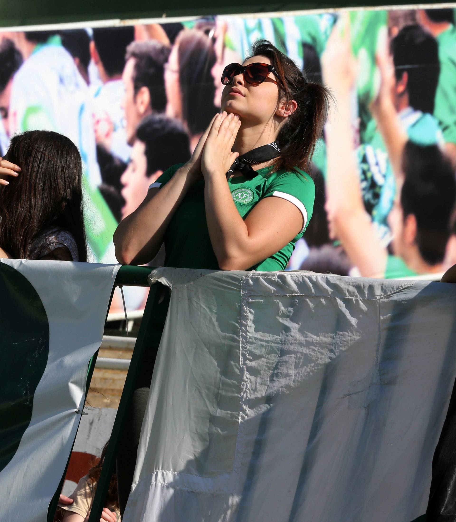 A fan of Chapecoense soccer team prays at the Arena Conda stadium in Chapeco