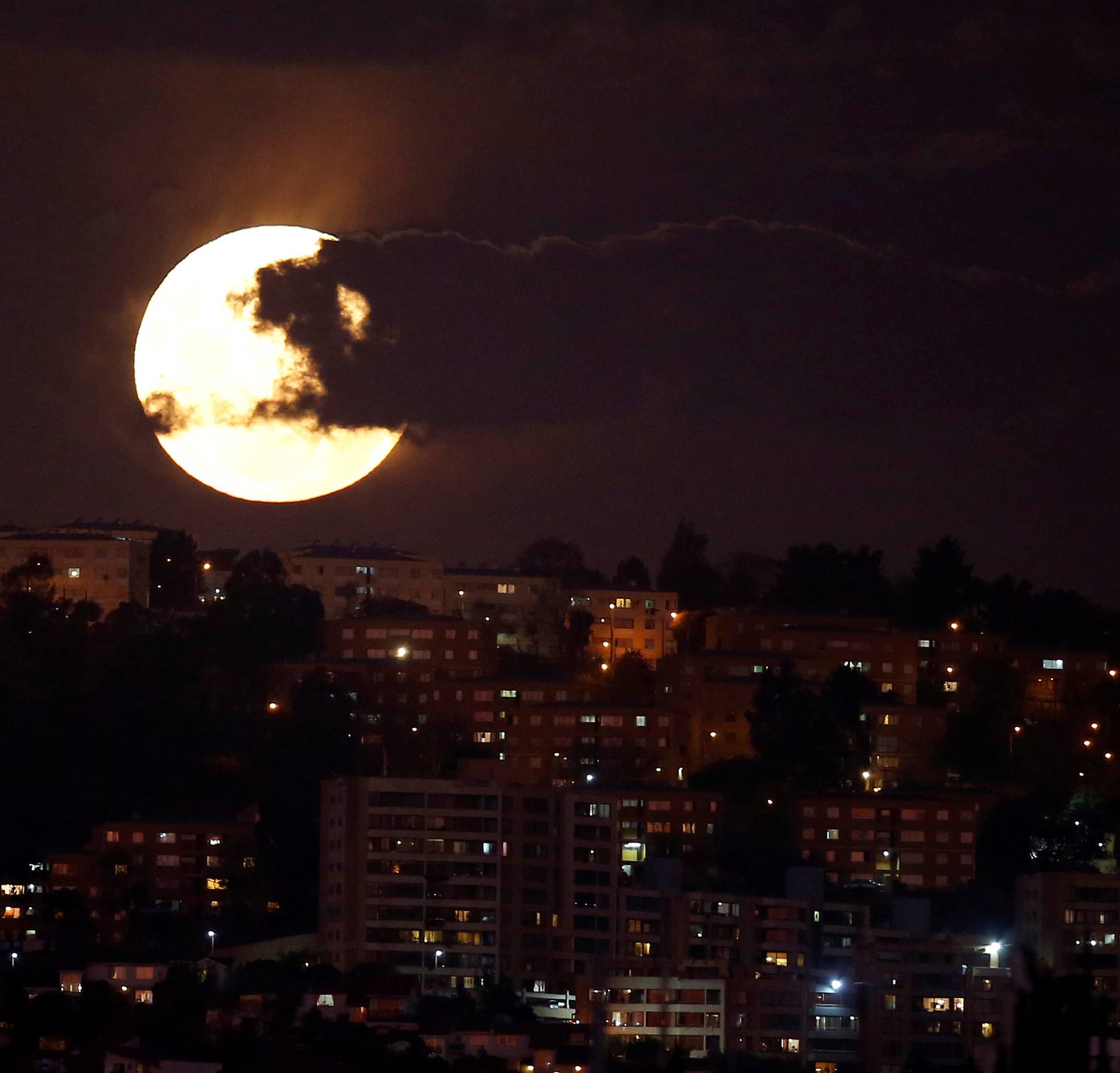 A supermoon rises in the sky at the city of Vina del Mar