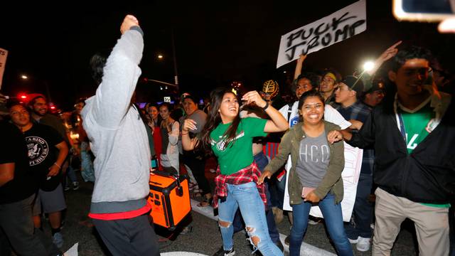 Demonstrators dance in the street outside Republican U.S. presidential candidate Donald Trump's campaign rally in Costa Mesa