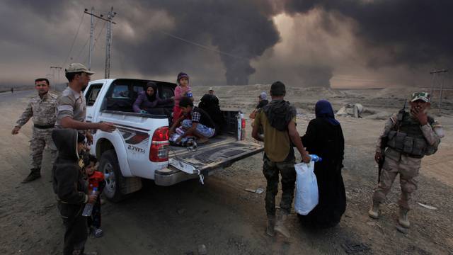 Displaced people who are fleeing from clashes arrive in Qayyarah, during an operation to attack Isla mic State militants in Mosul