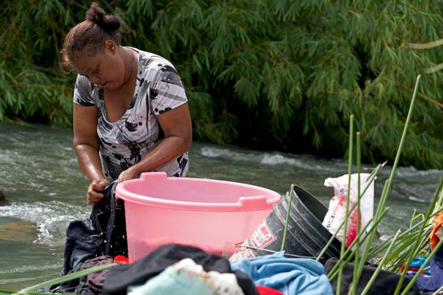 Woman washes clothes in a river after Hurricane Beryl knocked out electricity and water service in Grenada
