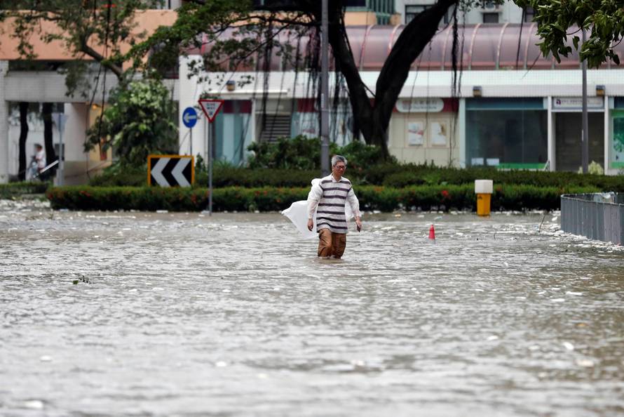 A man walks through a flooded street as Typhoon Hato hits Hong Kong