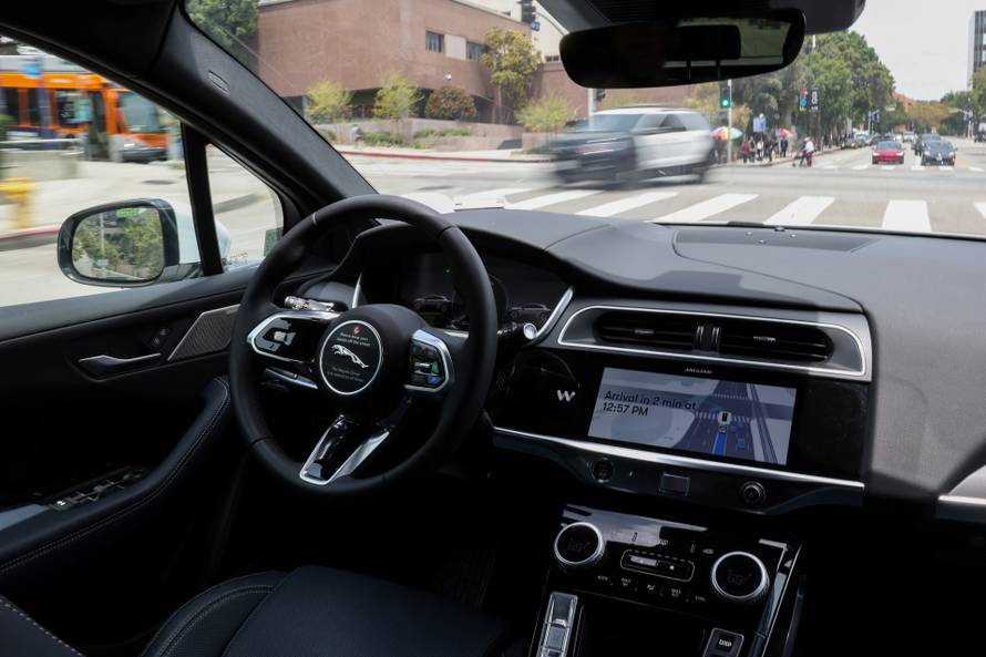A self-driving Waymo car drives through Los Angeles