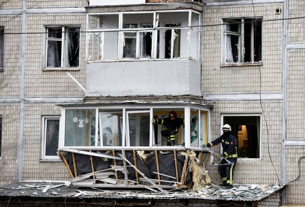 Emergency responders work at the site of a Russian drone strike on an apartment building, in Kyiv