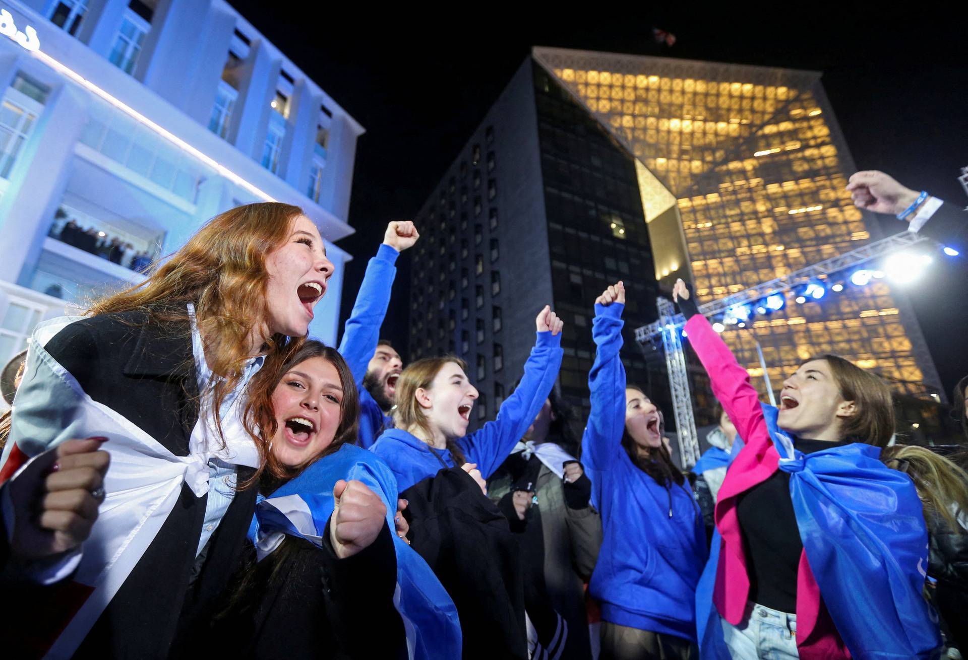 Supporters of the Georgian Dream party celebrate after the announcement of exit poll results in Tbilisi