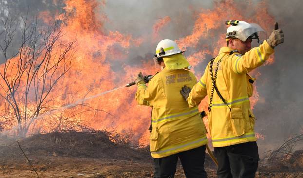 New South Wales Rural Fire Service firefighters are seen fighting fires on Long Gully Road in the northern New South Wales town of Drake