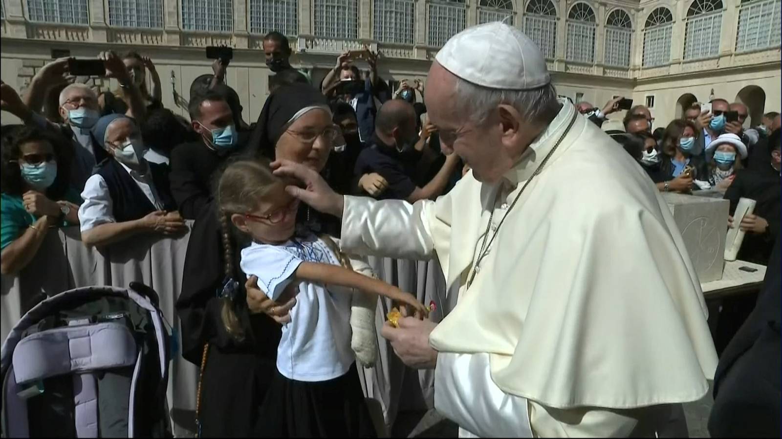 Pope Francis blesses a young girl as he leaves the first weekly general audience to readmit the public since the coronavirus (COVID-19) outbreak in the San Damaso courtyard